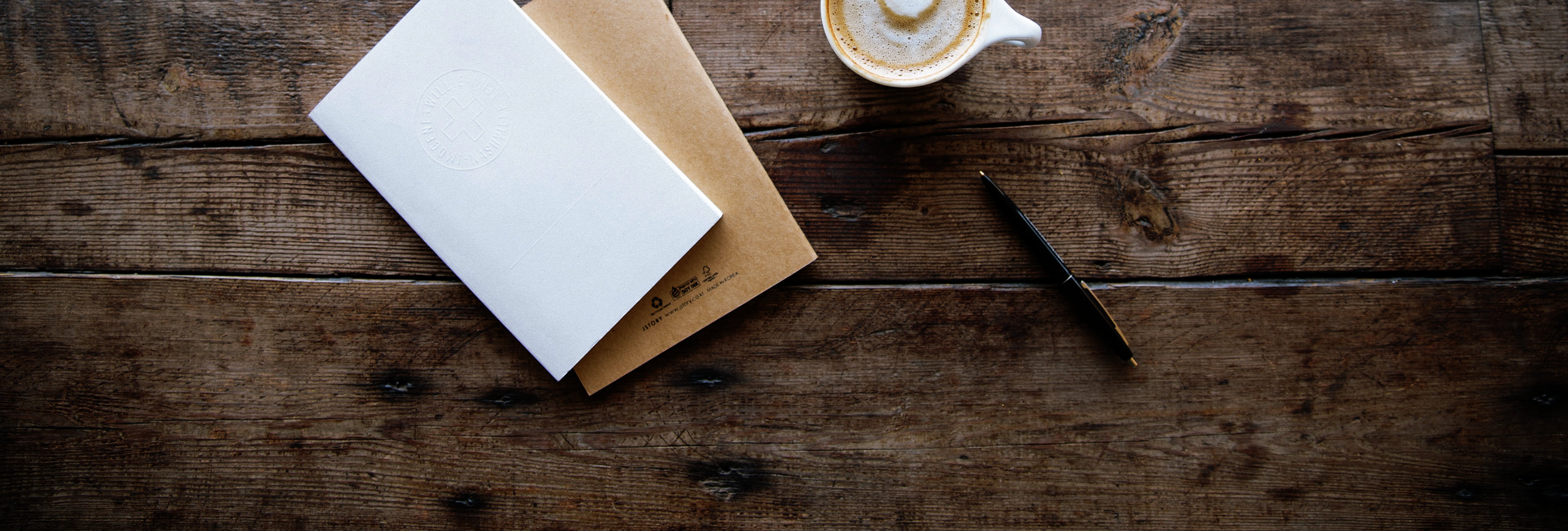 Długopis, dokumenty i kawa leżące na stole